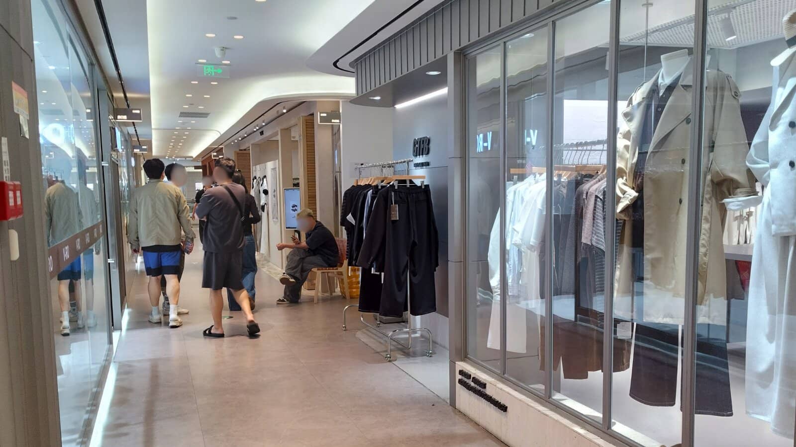 広州・恵美国際のメンズフロア。ガラス張りの店舗にトレンチコートやジャケットが並ぶ